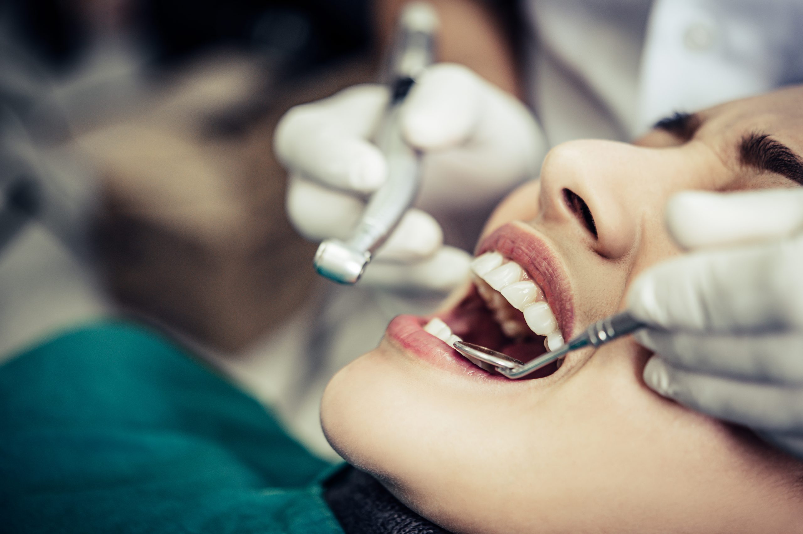 The dentist examines the patient’s teeth.